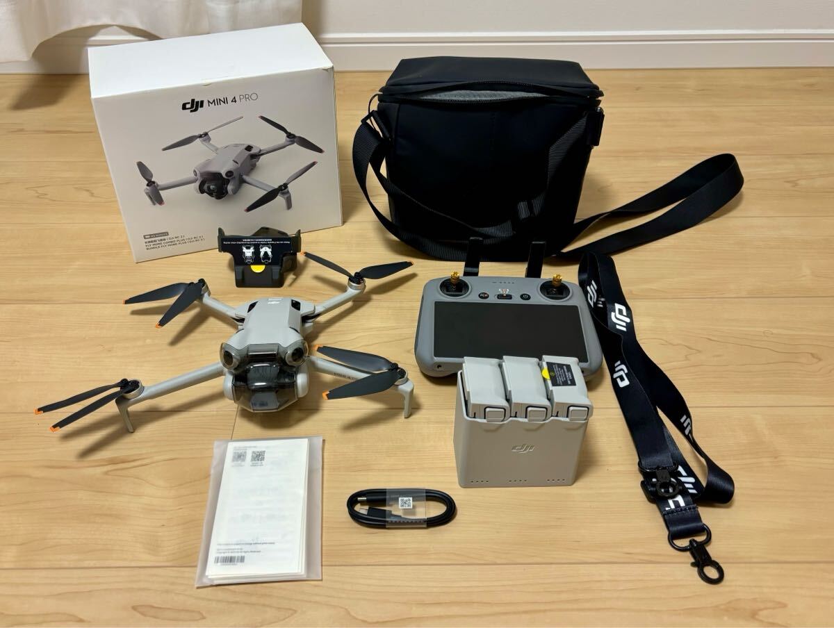 Excellent condition DJI Mini 4 Pro drone, complete with accessories: RC2 controller, storage bag, camera, and photography equipment.